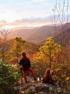 Fall Hiking with a sunset overlooking the colorful mountain foliage.